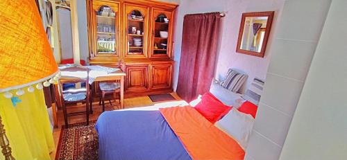 a bedroom with a bed and a table in a room at Gîte Studio Saint Ribert in La Rochette