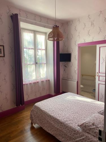 - une chambre avec un lit doté de rideaux violets et d'un miroir dans l'établissement Corbeilles, à Auxy