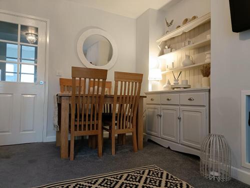 a kitchen with a table and chairs and a mirror at Charming Terrace Home in Whitchurch in Whitchurch