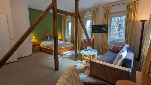 a living room with a bed and a couch in a room at Naturhotel Forsthaus in Annaberg-Buchholz