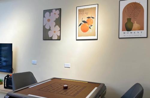 a laptop sitting on a desk with pictures on the wall at 陌上花民宿 電麻switch烤肉抓周派對 in Hualien City