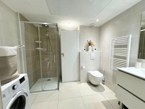 a bathroom with a shower toilet and a washing machine at Magnifique studio bohème neuf cœur de ville in Antibes