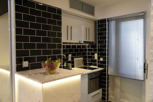 une cuisine avec un comptoir avec un bol de fruits dessus dans l'établissement Syntagma square, 30sqm Nikis luxurious Studio, à Athènes
