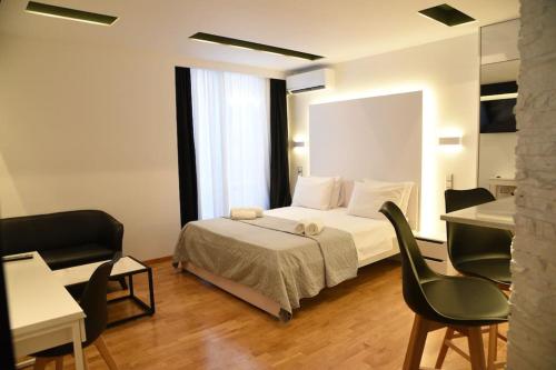 une chambre avec un lit, un bureau et des chaises dans l'établissement Syntagma square, 30sqm Nikis luxurious Studio, à Athènes