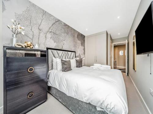 Un dormitorio con una cama grande y una pared en Pass the Keys Penthouse Oasis in Trendy Fulham, en Londres