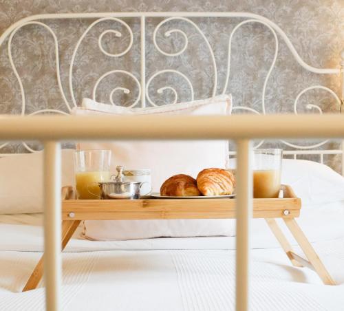アルゲーロにあるGuest House Camillaのベッドの上にパンとペストリーのトレイ