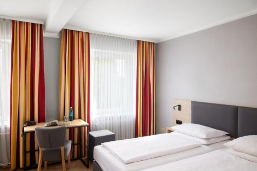a hotel room with a bed and a desk with a desk at Hotel Central Hamburg in Hamburg