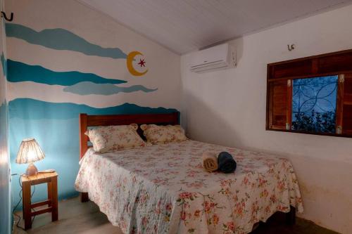um quarto com uma cama com um quadro na parede em Casa Flora Canoa Quebrada em Canoa Quebrada