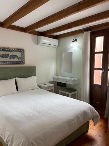 a bedroom with a white bed and a window at Erietta Suites in Chania Town