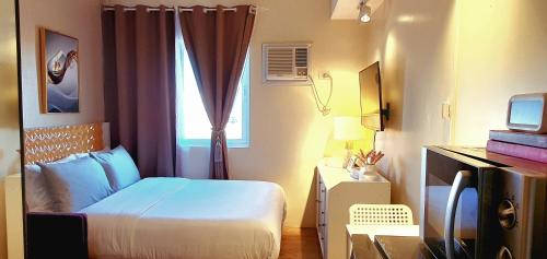 um pequeno quarto com uma cama e uma janela em Serenity Condo: Your Cozy Place At Stanford Suites 2 w/ Private Parking em Silang