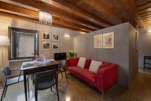a living room with a red couch and a table at Residenza Roccamaggiore in Verona