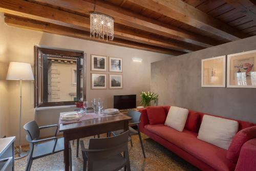 a living room with a red couch and a table at Residenza Roccamaggiore in Verona