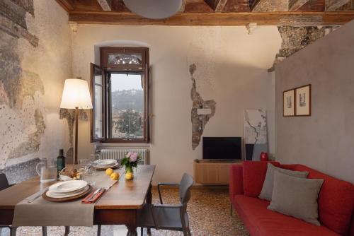 a living room with a table and a red couch at Residenza Roccamaggiore in Verona