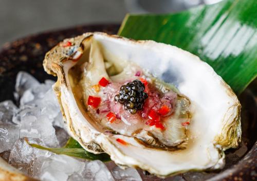 a oyster with a blackberry and other ingrediants on ice at The Prince Akatoki London in London