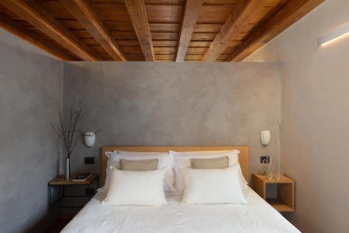 a bedroom with a bed with white sheets and pillows at Residenza Roccamaggiore in Verona