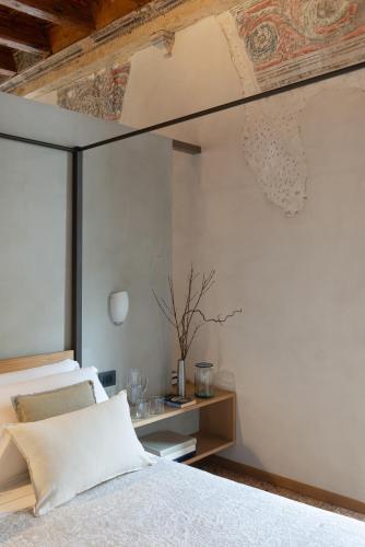 a bedroom with a white bed with a wooden ceiling at Residenza Roccamaggiore in Verona