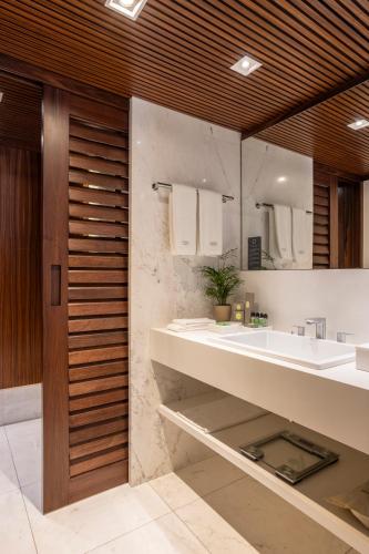 a bathroom with two sinks and a mirror at L'Hotel PortoBay São Paulo in Sao Paulo