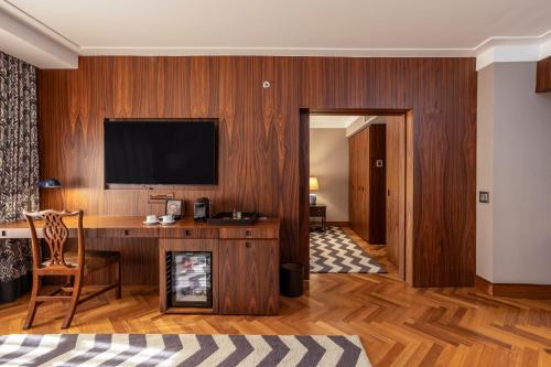 a room with a desk and a television on a wall at L'Hotel PortoBay São Paulo in Sao Paulo