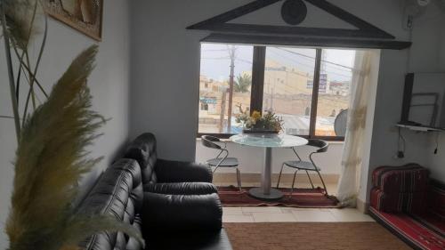 sala de estar con sofá, mesa y ventana en M.T Apartments en Madaba