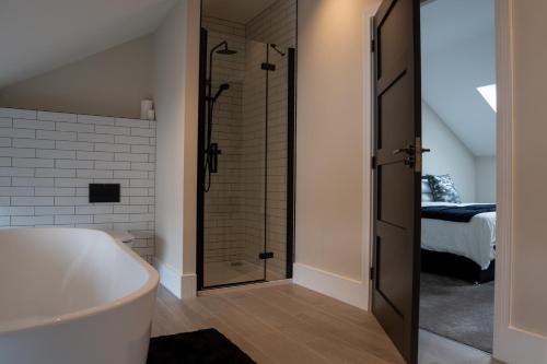 La salle de bains est pourvue d'une baignoire et d'une douche. dans l'établissement Luxury Worcester Townhouse - Free Parking, à Henwick