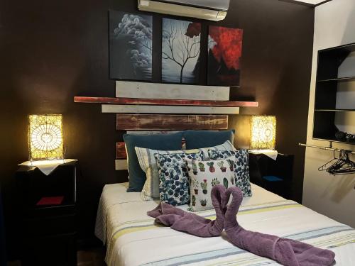 ein Schlafzimmer mit einem Bett mit zwei Fingerhandschuhen darauf in der Unterkunft Sunrise House in Quepos
