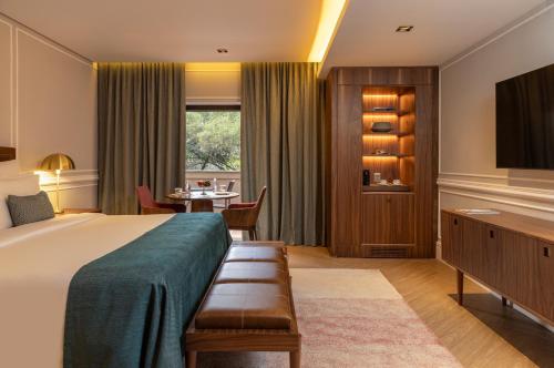 a hotel room with a large bed and a table at L'Hotel PortoBay São Paulo in Sao Paulo