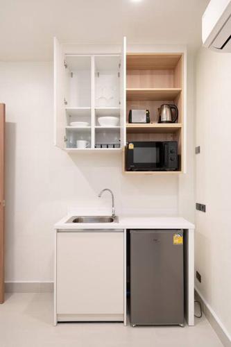 a kitchen with a sink and a microwave at Townhouse in Pratunam Bangkok in Bangkok