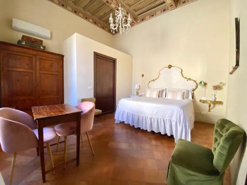 1 dormitorio con 1 cama, mesa y sillas en 1550 Residenza d’Epoca en Siena