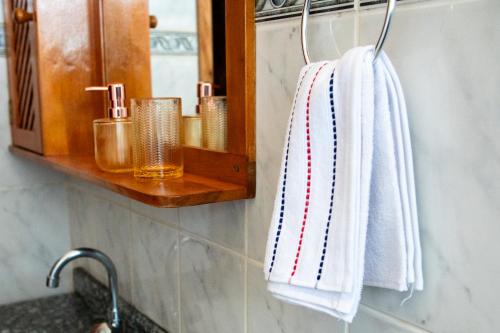貢薩爾維斯的住宿－Respiro na Serra, casa no coração de Gonçalves，浴室设有可悬挂在镜子上的白色毛巾