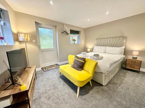 a bedroom with a bed and a yellow chair at Firs Nook with Parking in Stillington