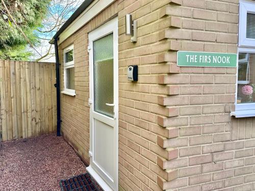 a building with a door and a sign on it at Firs Nook with Parking in Stillington