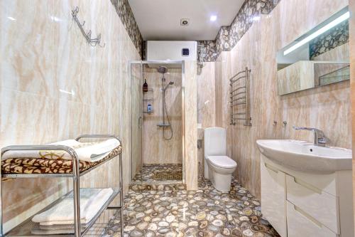 ein Bad mit einer Dusche, einem Waschbecken und einem WC in der Unterkunft Апартаменти 3-кімнатні поруч зі ст. м. Звіринецька in Kiew