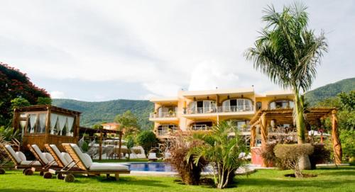 a large house with chairs and a swimming pool at El Chante Spa Hotel in Jocotepec