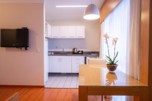 a kitchen with a table with a plant on it at eSuítes Congonhas by Atlantica in Sao Paulo
