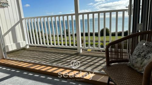 a balcony with a chair and a view of the ocean at Luna's Seaview Apartment Sleeps 4 Parking Beach in Kent