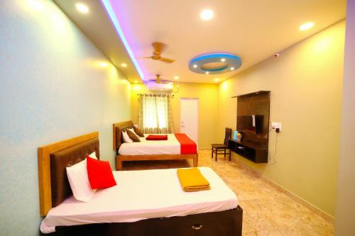 une chambre d'hôtel avec deux lits et une télévision dans l'établissement DayLight Stay, à Chennai