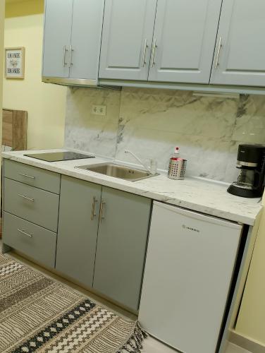 a kitchen with white cabinets and a sink at Black Eagle's Nest (studio) in Drama