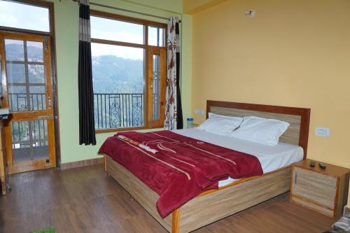 a bedroom with a bed and a large window at New Summer Capital in Shimla