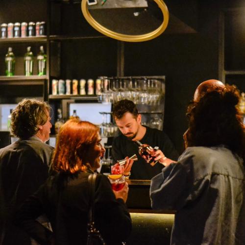 a group of people standing around a bartender at EDIT Lofts in Turin
