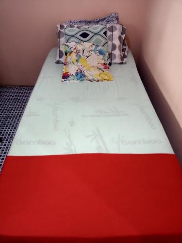 Ce lit se trouve dans un dortoir doté d'un matelas rouge et blanc. dans l'établissement Alojamento do João, à Lagoa Santa