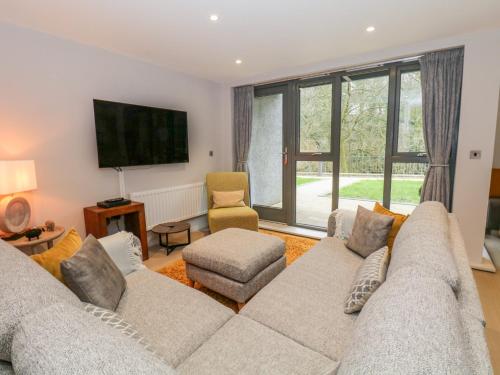 a living room with a couch and a tv at Rivers Edge in Ulverston
