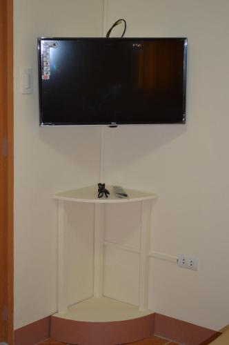 a flat screen tv hanging on a wall at Manora Apartment in Talisay