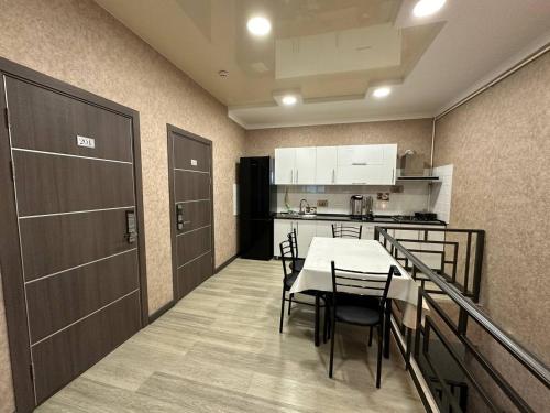 タシュケントにあるVip Hotelのテーブルとキッチンのあるダイニングルーム