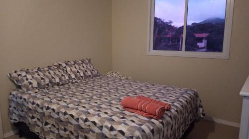 uma cama com duas almofadas num quarto em Terraço Guaramiranga em Mulungu