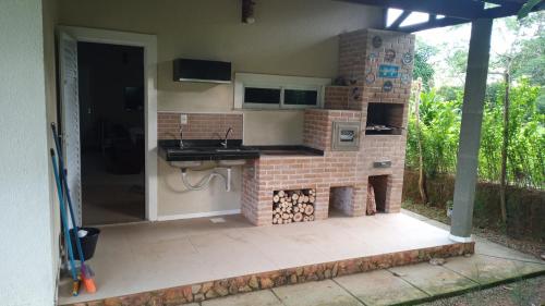 uma cozinha com lareira de tijolos numa casa em Terraço Guaramiranga em Mulungu
