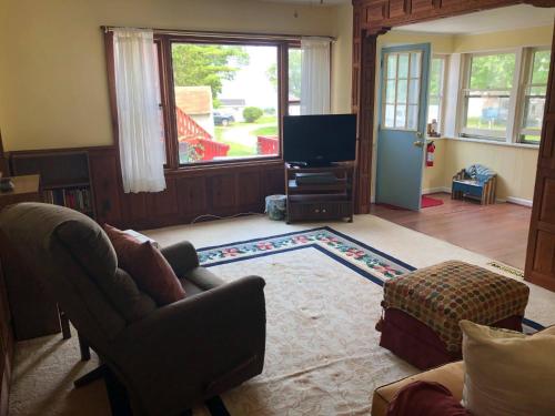 sala de estar con sofá y TV en Entire Lake Huron sunrise family home with 160 feet of private Beach, en Keewahdin