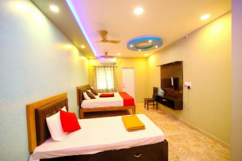 une chambre d'hôtel avec deux lits et une télévision dans l'établissement DayLight Stay, à Chennai