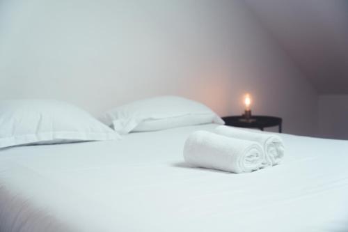 - un lit blanc avec une pile de serviettes dans l'établissement L'Âme de l'Artiste - Quartier Velpeau, à Tours