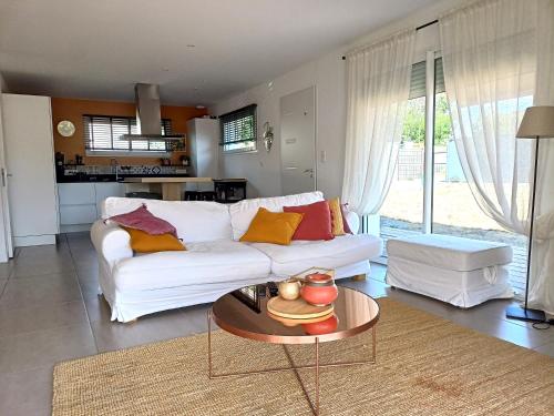 un salon avec un canapé blanc et une table dans l'établissement chez Stéph, à Salles