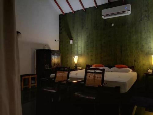 1 Schlafzimmer mit 2 Betten und 2 Stühlen in der Unterkunft kenuson yala in Tissamaharama